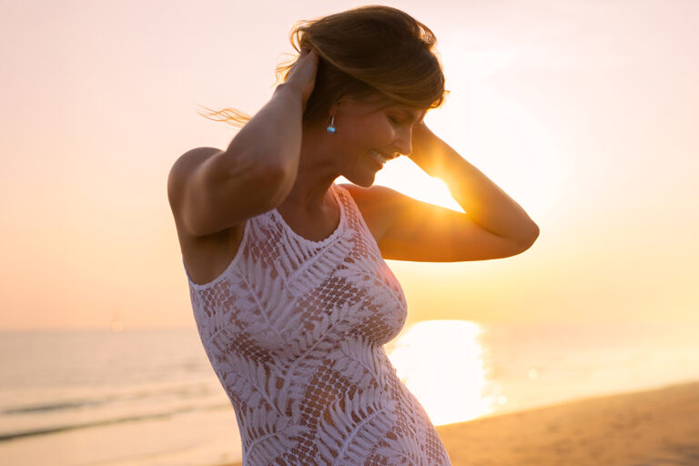 Woman relaxing at the beach, representing recovery and soreness after liposuction in Palm Beach.