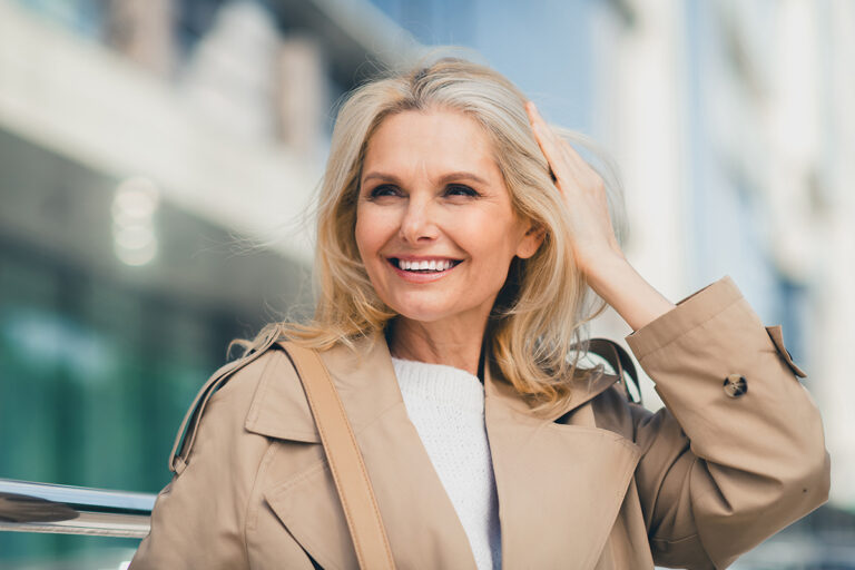 Smiling mature woman representing mini-facelift options for facial rejuvenation in Palm Beach.
