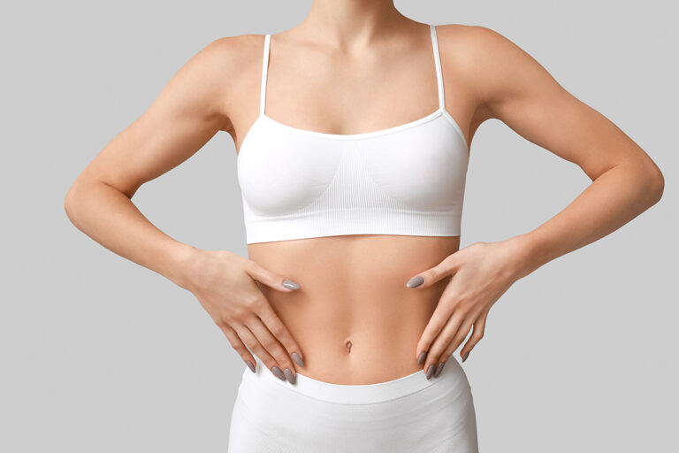 Woman showing her abdomen, representing tummy tuck revision for persistent loose skin in Palm Beach.