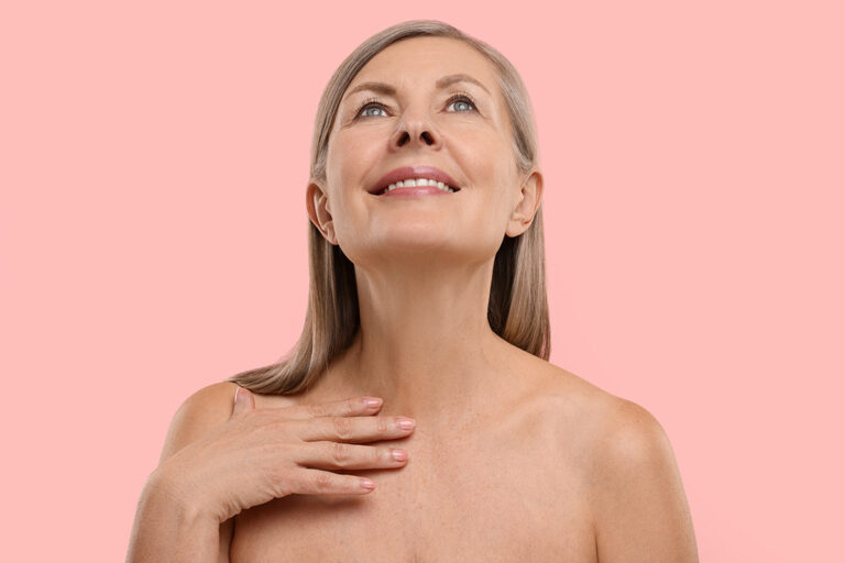 Mature woman touching her neck, representing neck lift treatment for a smoother neckline in Palm Beach Gardens.