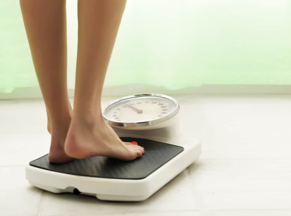 Woman with lipedema stepping on scale