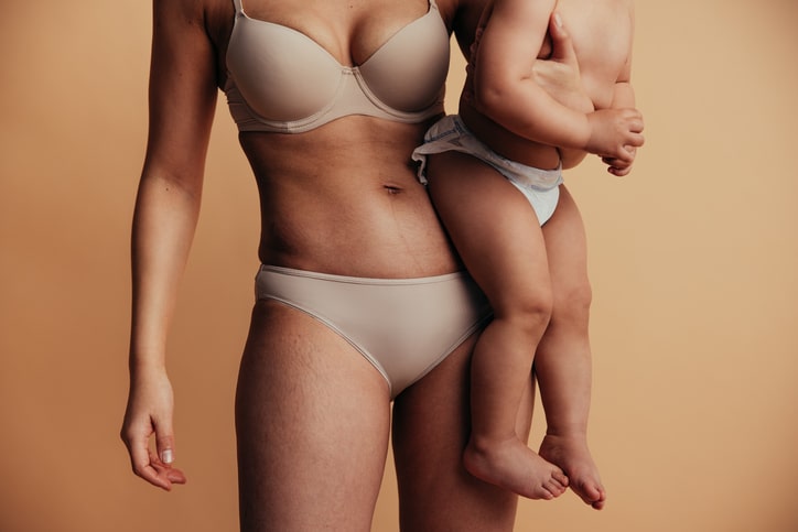 Mother holding her child, representing Mommy Makeover surgery after pregnancy in Palm Beach Gardens.