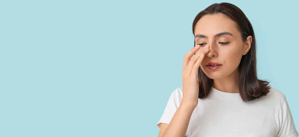 Woman touching her nose, representing septoplasty for improved nasal airflow in Palm Beach Gardens.